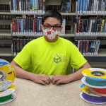 Teen is pictured with spools of 3d printer filament