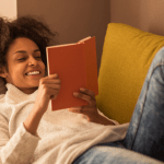 woman lounges on couch, reading